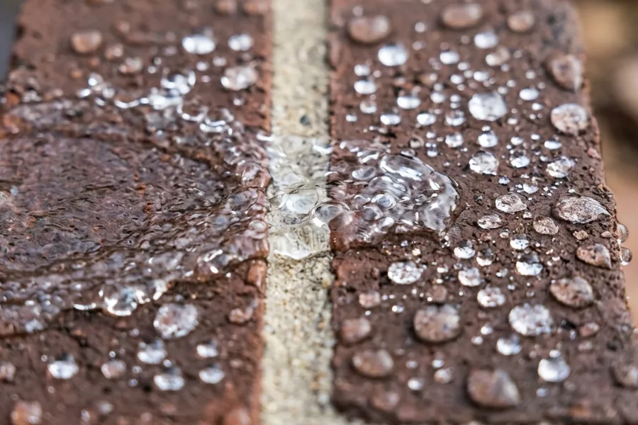 Waterdruppels die afparelen op geïmpregneerde baksteen