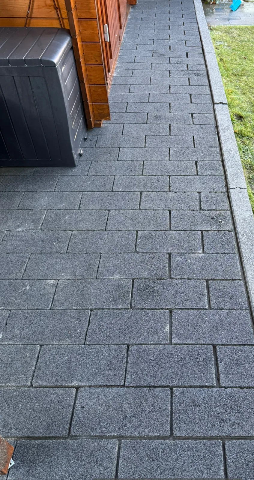 Hetzelfde tuinpad na reiniging, de klinkers weer donkergrijs