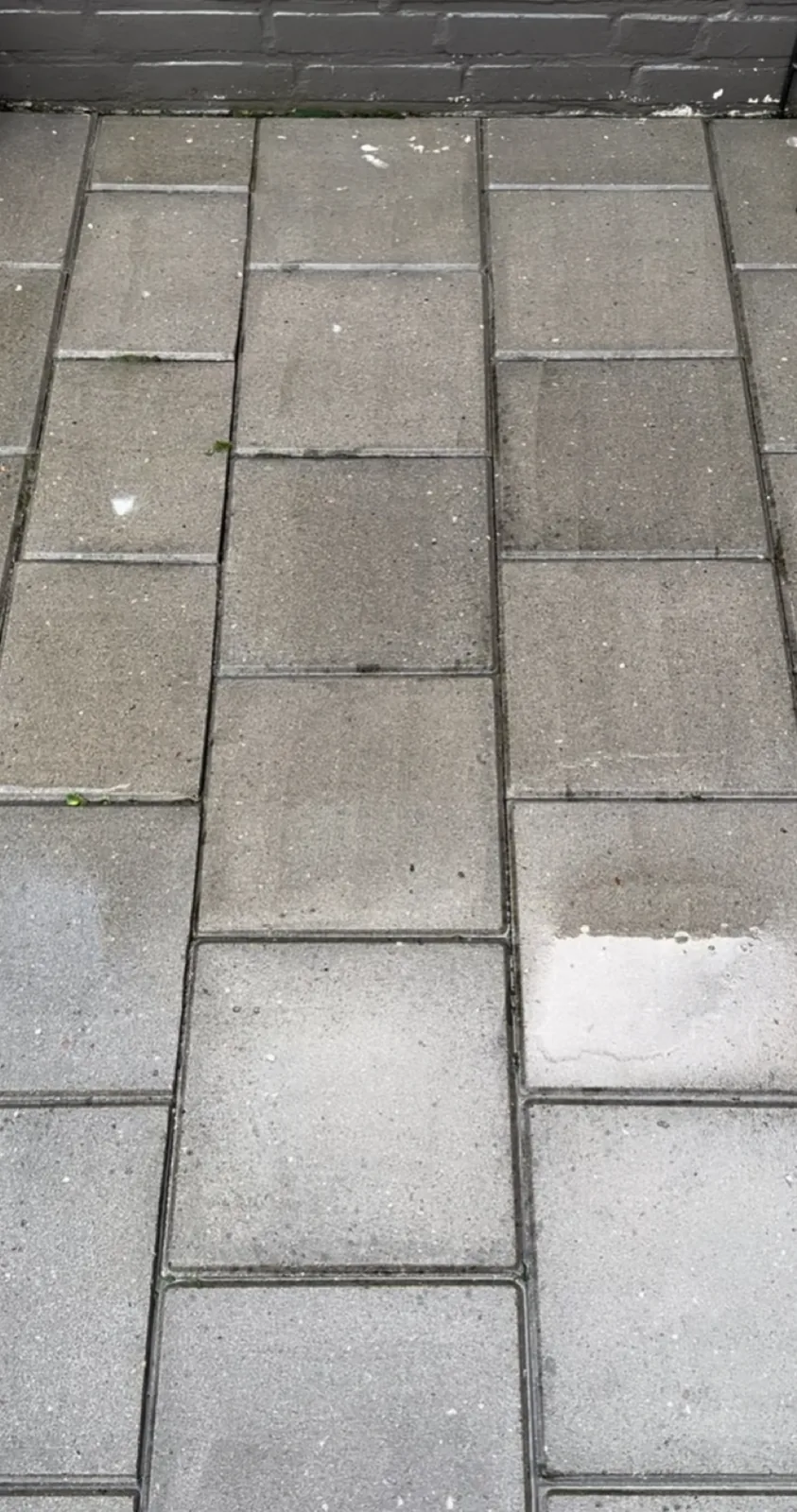 Hetzelfde terras na reiniging, de tegels egaal lichtgrijs